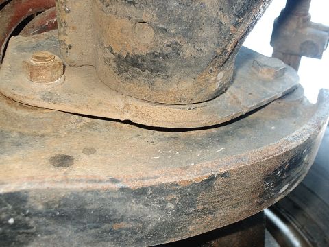 1996 Ford Bronco - A close-up view of a rusty suspension component, showing bolts and layered metal plates.
