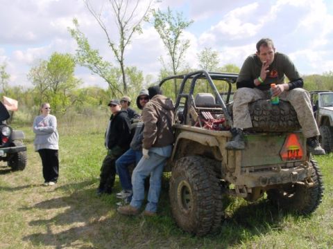 1992 Ford Bronco - Group of people standing around a modified off-road vehicle in an outdoor setting.