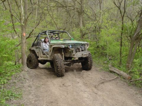 1992 Ford Bronco - This modified Suzuki Samurai is navigating a challenging off-road trail with a driver and passenger inside.
