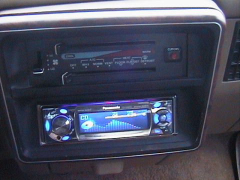 1991 Ford Bronco - The interior of a vehicle displays climate controls above a modern Panasonic stereo system.