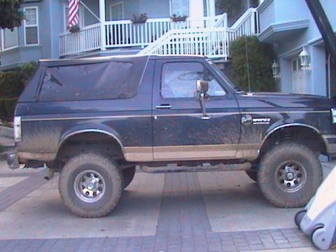 1991 Ford Bronco - Side view of a 1991 Ford Bronco, showing its dark blue paint and tan trim.