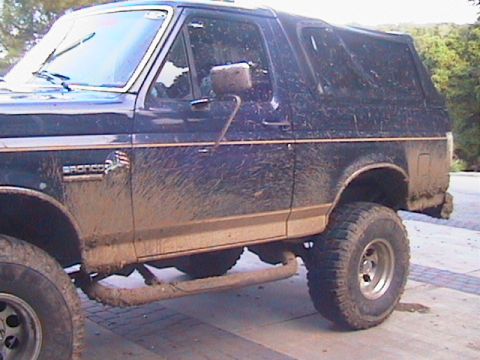 1991 Ford Bronco - This Ford Bronco shows significant mud coverage, indicating off-road use.