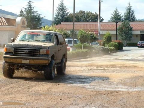 1991 Ford Bronco - This 1991 Ford Bronco is captured mid-turn on a dusty, unpaved surface.