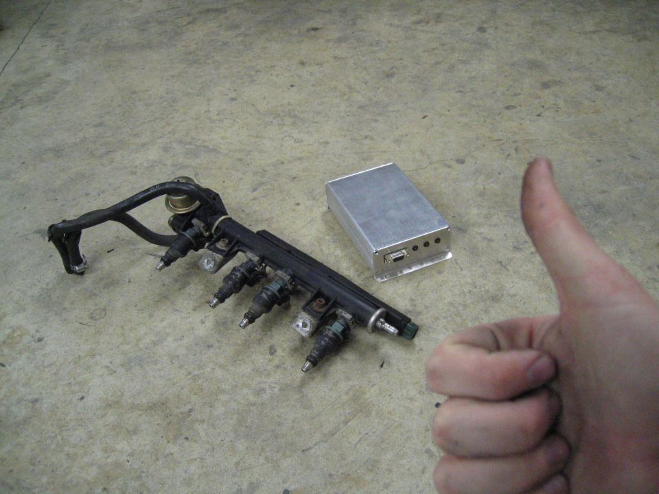 Fuel rail with four injectors and a silver metal box with ports