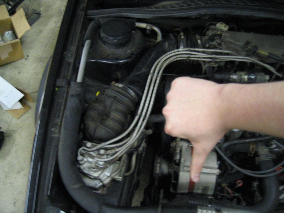 Car engine bay with a hand giving a thumbs down gesture. "SUPERMOTORS www.supermotors.net" text is visible