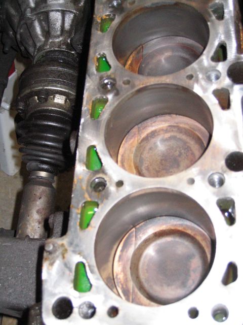 1987 Volkswagen Golf - Close-up view of an engine block's cylinders and pistons, with green coolant visible in the passages.