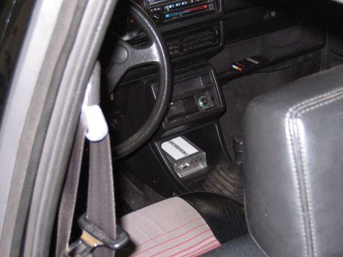 1987 Volkswagen Golf - The interior of a car features a steering wheel, dashboard, and a small amplifier installed under the dash.