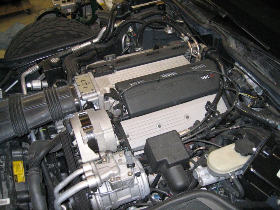 Chevrolet Corvette LT1 V8 engine bay with black Corvette cover and chrome alternator