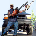 1993 Ford Bronco - A man poses with chainsaws in front of a modified truck.
