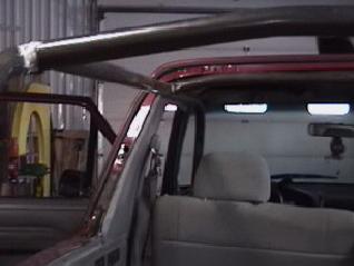 1994 Ford Bronco - Interior view of a red SUV with a custom roll cage installed.