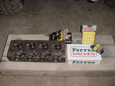 1978 Ford F-250 - Engine cylinder head and new valve components are laid out on wooden planks.