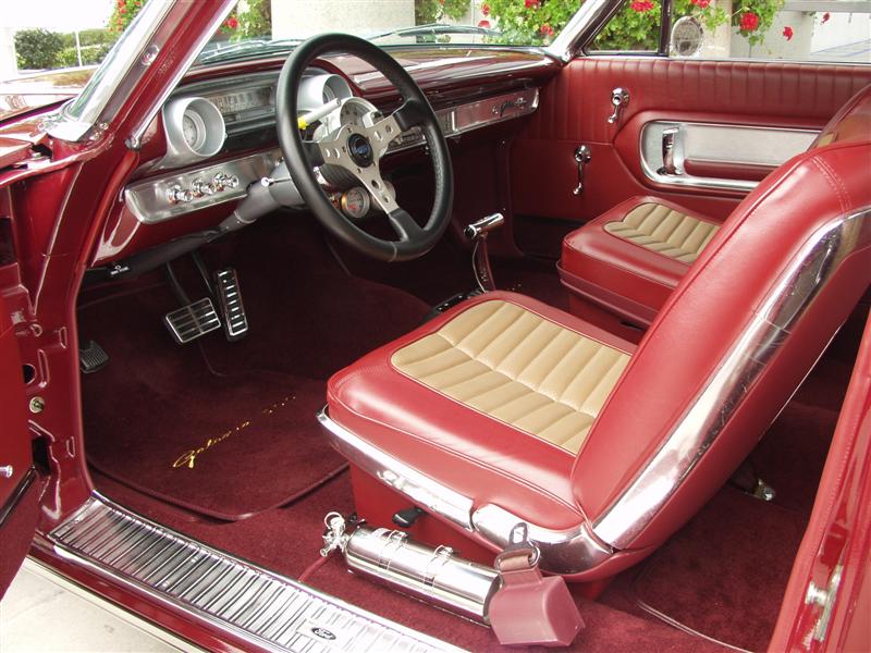 Red and tan bucket-seat interior of restored hardtop with chrome console