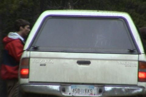 1979 Ford Bronco - The rear of a Toyota Tacoma pickup truck is shown, a camper shell and a license plate.