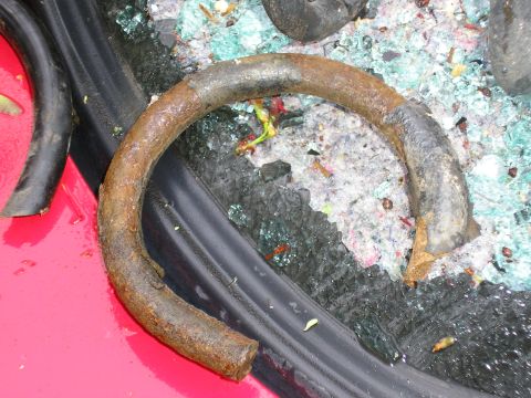 1998 Ford Taurus - A close-up view of a broken spring and debris on the exterior of a red vehicle.