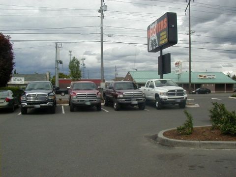 1994 Ford Explorer - Several Dodge Ram trucks are parked in a lot outside a Hooters restaurant.