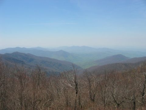 1985 Ford LTD Crown Victoria - A scenic view of rolling mountains, possibly along the Cherohala Skyway, under a bright blue sky.