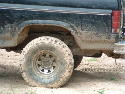 1993 Ford Bronco - This heavily soiled vehicle shows the rear wheel and body of a Ford Bronco from the 1980s.