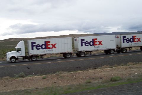 1994 Ford F-150 - A white FedEx semi-truck pulls two trailers on a highway under a cloudy sky.