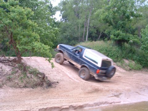1993 Ford Bronco - A Ford Bronco navigates a sandy incline during an off-road excursion.
