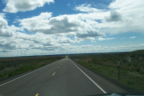 1994 Ford F-150 - A vast, open landscape with a road disappearing into the distance under a dramatic sky.