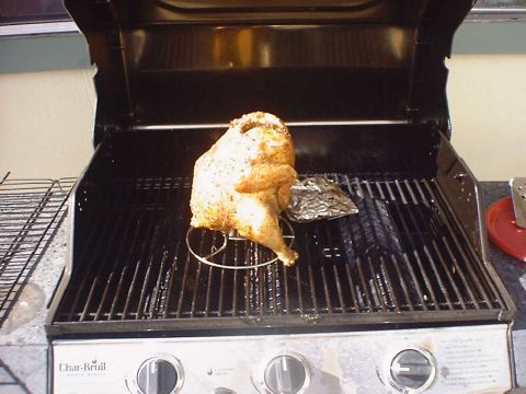 1988 Ford Bronco - A seasoned chicken is prepared for grilling on a rotisserie rack.