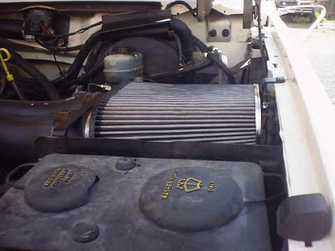 1988 Ford Bronco - Close-up view of the engine bay, an aftermarket air filter and fluid reservoirs.