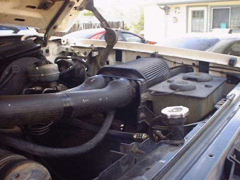 1988 Ford Bronco - Close-up of an engine bay with an aftermarket air intake system installed.