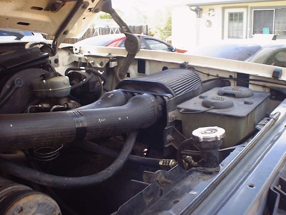 Open-element cone air filter and flex intake tube in a truck engine bay with hood raised