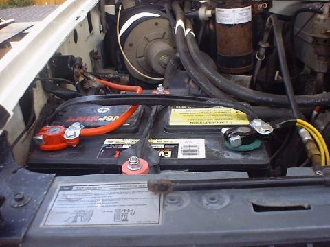 1988 Ford Bronco - Close-up view of the engine bay, focusing on the battery setup and associated wiring.