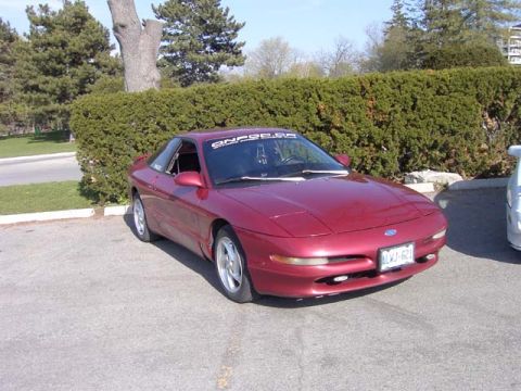 1989 Ford Probe - A red 1989 Ford Probe is parked outdoors, viewed from the front-left quarter angle.