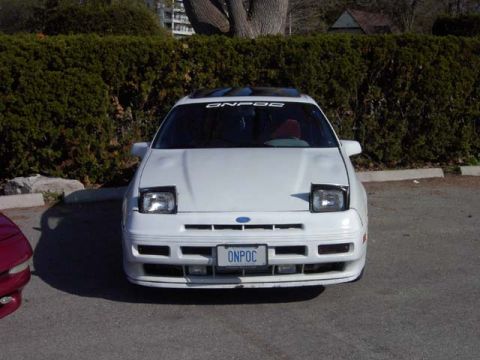 1989 Ford Probe - Front view of a white Ford Probe, pop-up headlights and a license plate reading ONPOC.