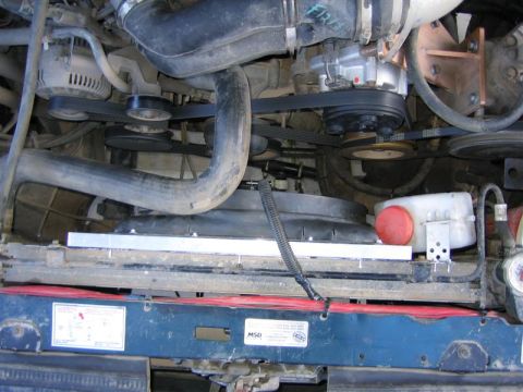 1994 Ford Bronco - Close-up view of the engine bay, focusing on the radiator, fan assembly, and serpentine belt system.