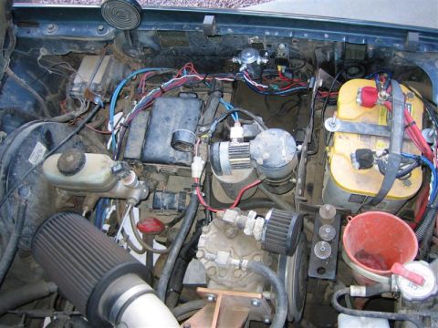 1994 Ford Bronco - Engine bay shows aftermarket modifications including an air filter and battery.