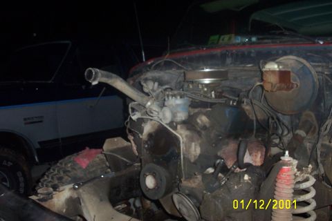1979 Ford F-150 - The engine bay of a 1979 Ford F-150 shows its V8 engine, with another vehicle partially visible to the left.