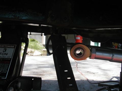 1994 Ford Bronco - Undercarriage view of a vehicle being worked on, with a floor jack and suspension parts visible.