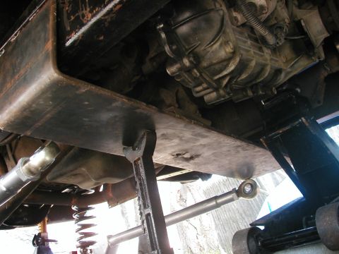 1994 Ford Bronco - Underbody view of a vehicle being worked on, showing the transmission and skid plate.