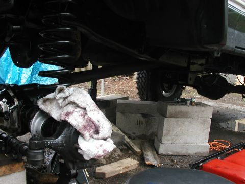 1994 Ford Bronco - The underside of a vehicle is shown with suspension parts exposed, indicating maintenance or repair work is in progress.