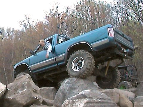1977 Ford F-150 - This blue pickup truck is navigating a rocky terrain with a second vehicle in the background.
