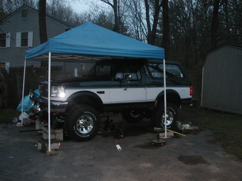 1994 Ford Bronco - This lifted 1994 Ford Bronco is parked under a blue canopy, possibly undergoing maintenance.