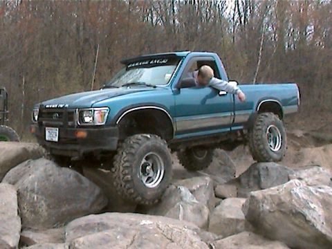 1977 Ford F-150 - This modified pickup truck is shown off-roading over large rocks.