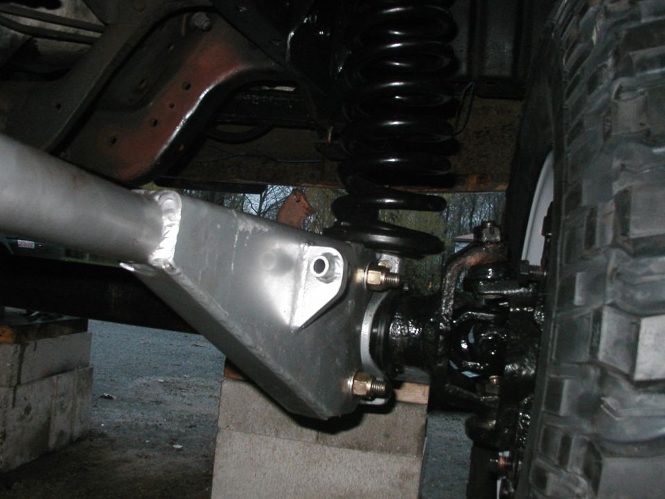 Close-up of a modified suspension component with a large coil spring and tire visible