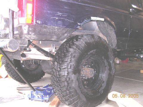 1994 Ford Bronco - Modified rear suspension and large tire on a 1994 Ford Bronco, seen during work.