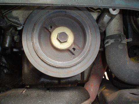 1993 Ford Taurus - A close-up view of an engine's crankshaft pulley, showing wear and oil residue.