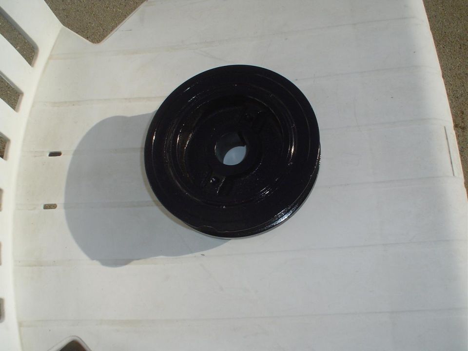 black harmonic balancer pulley on white plastic chair