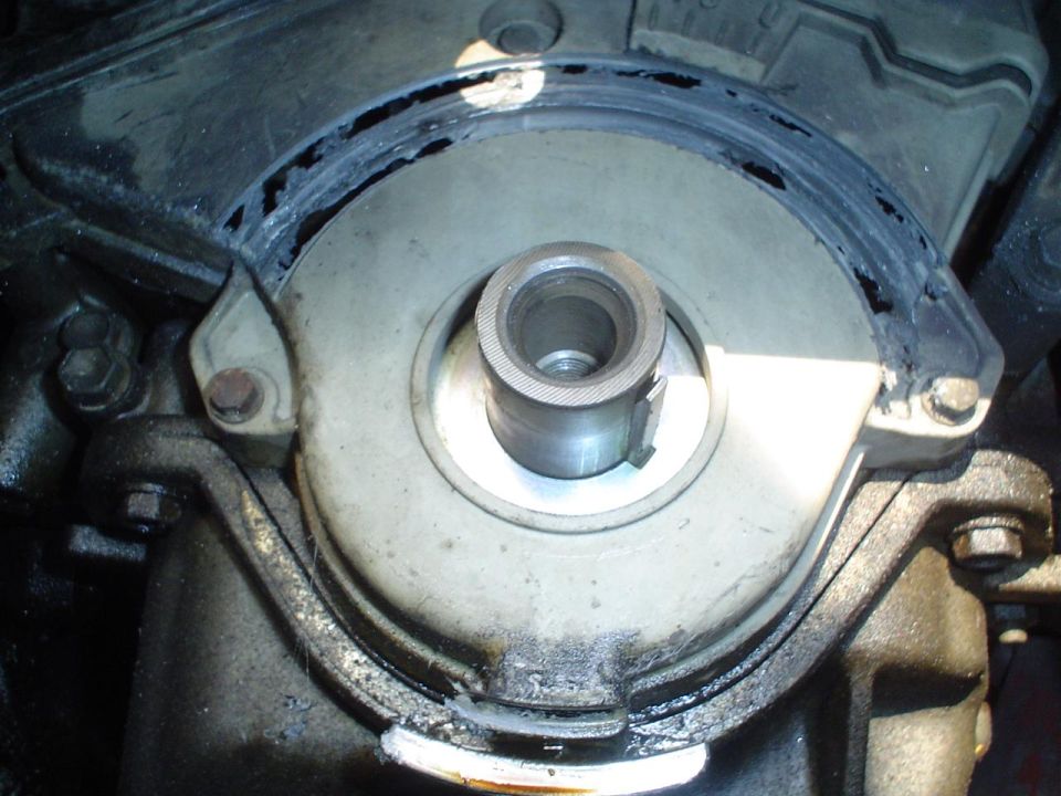 Close-up of engine crankshaft seal area with a metal shaft protruding