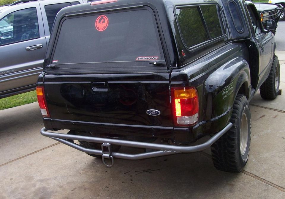 Rear of black Ford pickup with shell, tube bumper, D-ring and silver wheel in driveway