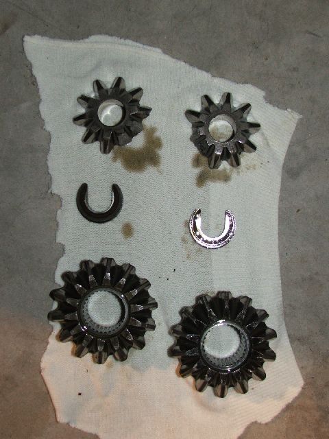1989 Ford Bronco - Differential spider gears and c-clips are shown on a white cloth, with a Supermotors.net watermark at the bottom.