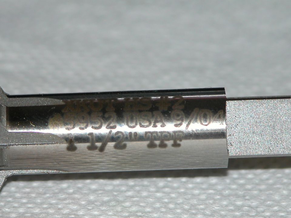 Close-up of polished metal tool stamped with markings including 1-1/2" TPF and 9/04