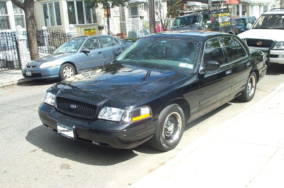 Black Ford Crown Victoria Police Interceptor on black steel wheels on a city street