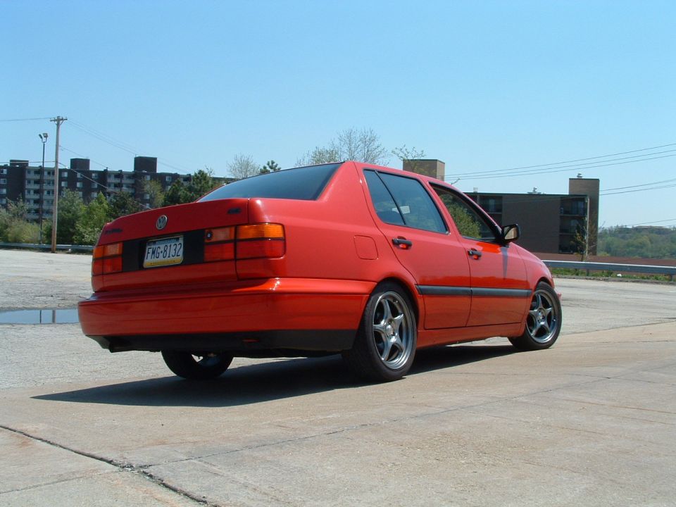 1994 Volkswagen Jetta sedan, rear 3/4 view, red paint, aftermarket wheels